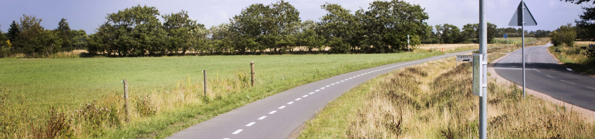 Dobbeltrettet cykelsti, der løber parallelt med en lille tosporet vej Dobbeltrettet cykelsti, der løber parallelt med en lille tosporet vej
